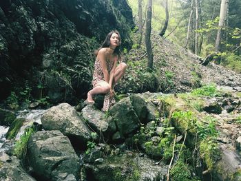 Woman on rock in forest