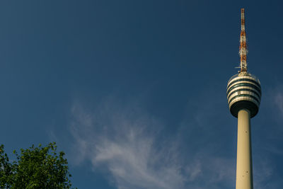 Low angle view of communications tower against cloudy sky