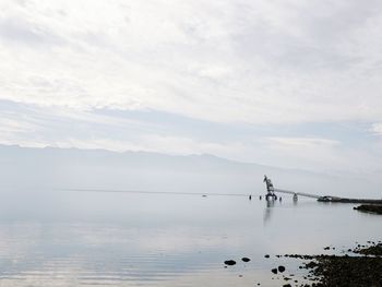 Scenic view of sea against cloudy sky