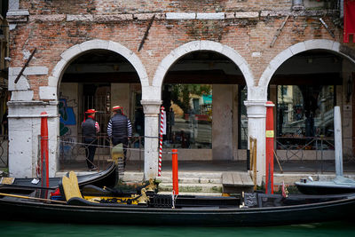 Rear view of man on boat against canal