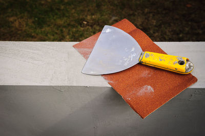 High angle view of chisel and sand paper on retailing wall