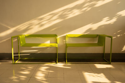 Empty chairs against tiled wall