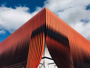 Low angle view of modern building against cloudy sky