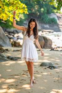 Side view of young woman standing at beach