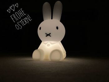 Close-up of figurine on table against black background