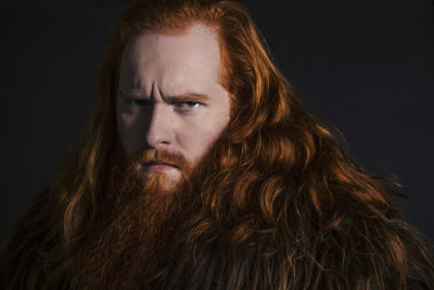 Portrait of man with long hair against gray background