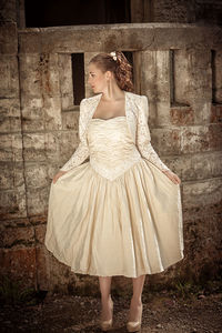 Portrait of woman standing against wall