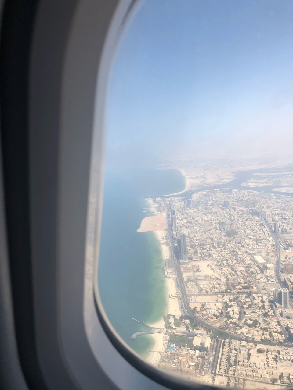 AERIAL VIEW OF CITY SEEN THROUGH AIRPLANE WINDOW