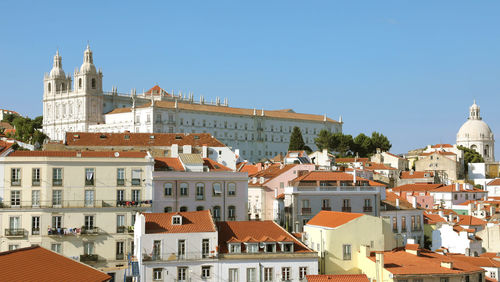 Buildings in city against clear sky