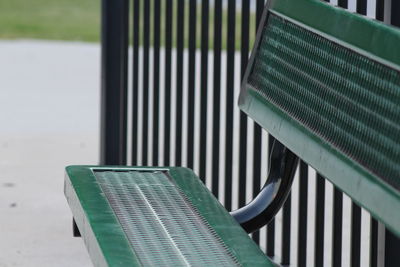 Green metallic bench by railing