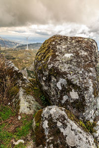 Close-up of rock on landscape against sky