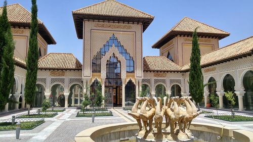 Statues in historic building against sky