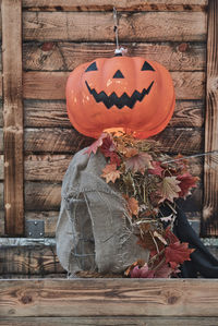 Close-up of pumpkin on wood against wooden wall during halloween