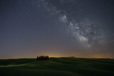 Scenic view of landscape against star field at night