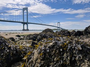 Suspension bridge over water against sky