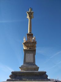 Low angle view of statue against blue sky