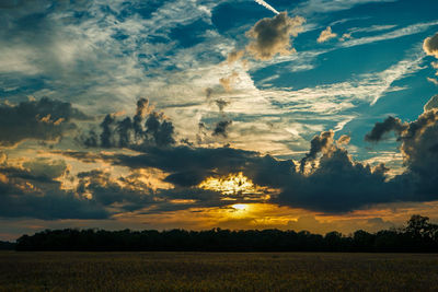 Scenic view of agricultural field against dramatic sky