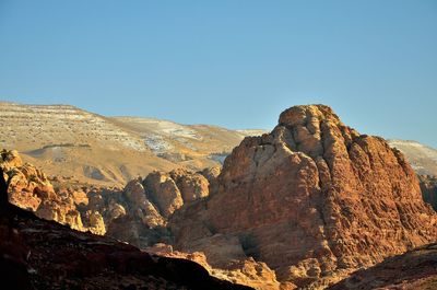 Low angle view of rock formations against clear blue sky