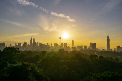 Buildings in city against sky during sunset