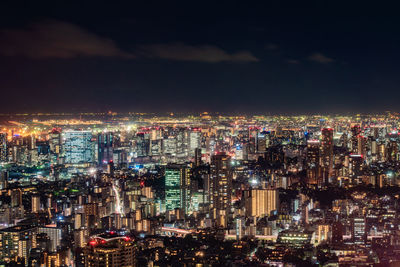 High angle view of illuminated cityscape against sky at night