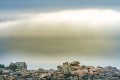 Rocks by sea against sky