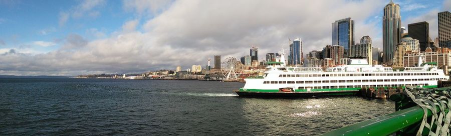 Panoramic view of sea and cityscape against sky