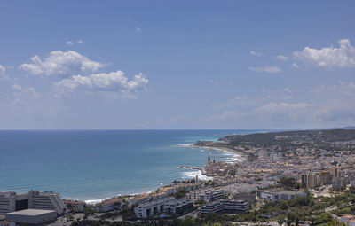 High angle view of townscape by sea against sky