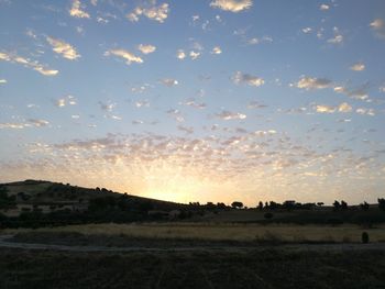 Scenic view of field against sky at sunset