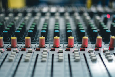 Close-up of knobs and push buttons on sound mixer
