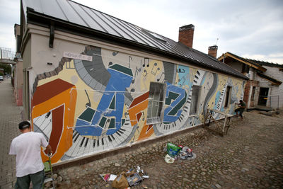 Graffiti on building against sky in city