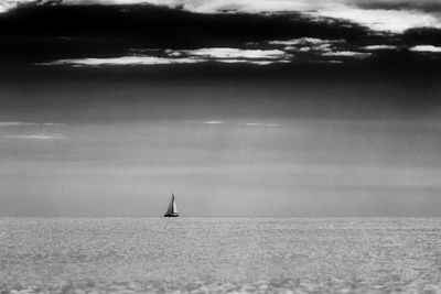 Sailboat sailing on sea against sky