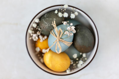 Multicolored easter eggs in a bowl, view from above. festive decoration.