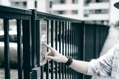 Cropped hand of man entering password in security system on gate