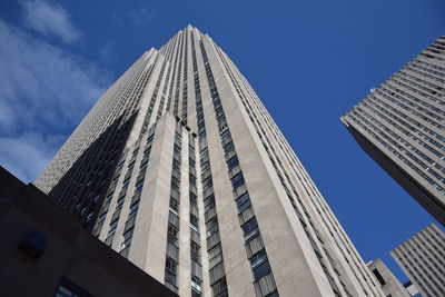 Low angle view of modern buildings against blue sky