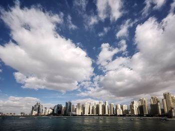 Buildings in city against cloudy sky