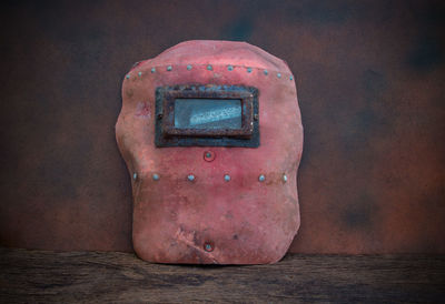 Close-up of protective mask on table against wall