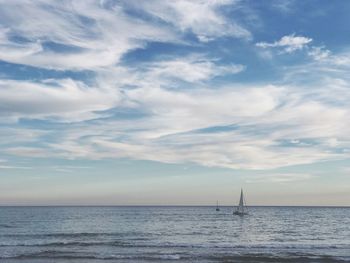 Sailboat sailing on sea against sky