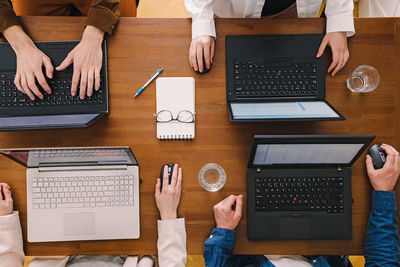 Cropped hands of man using laptop