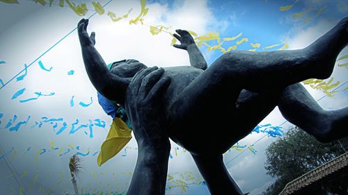 Low angle view of statue against blue sky