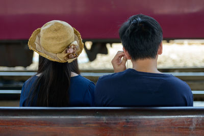 Rear view of couple sitting outdoors