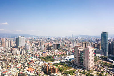 Aerial view of cityscape against blue sky