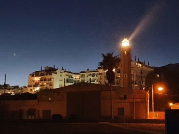 Illuminated buildings against sky at night