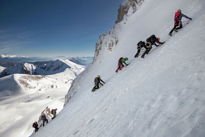 People climbing on snowcapped mountains during winter