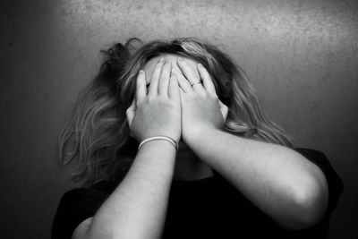 Woman covering face while lying on floor