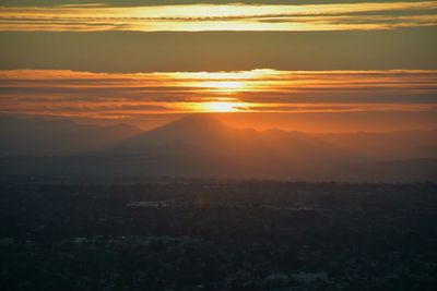 Scenic view of silhouette landscape against orange sky