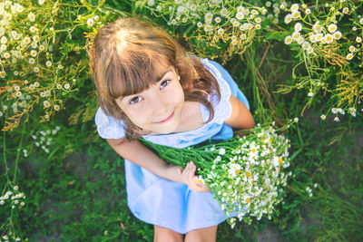 Smiling girl sitting amidst flowers