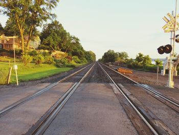 Railroad track amidst trees against clear sky