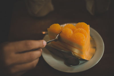 Close-up of hand holding orange fruit