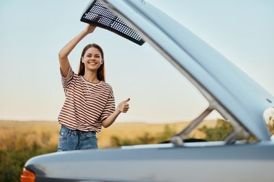 Full length of young woman exercising against sky