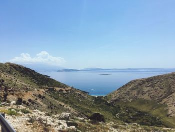 Scenic view of sea and mountains against blue sky